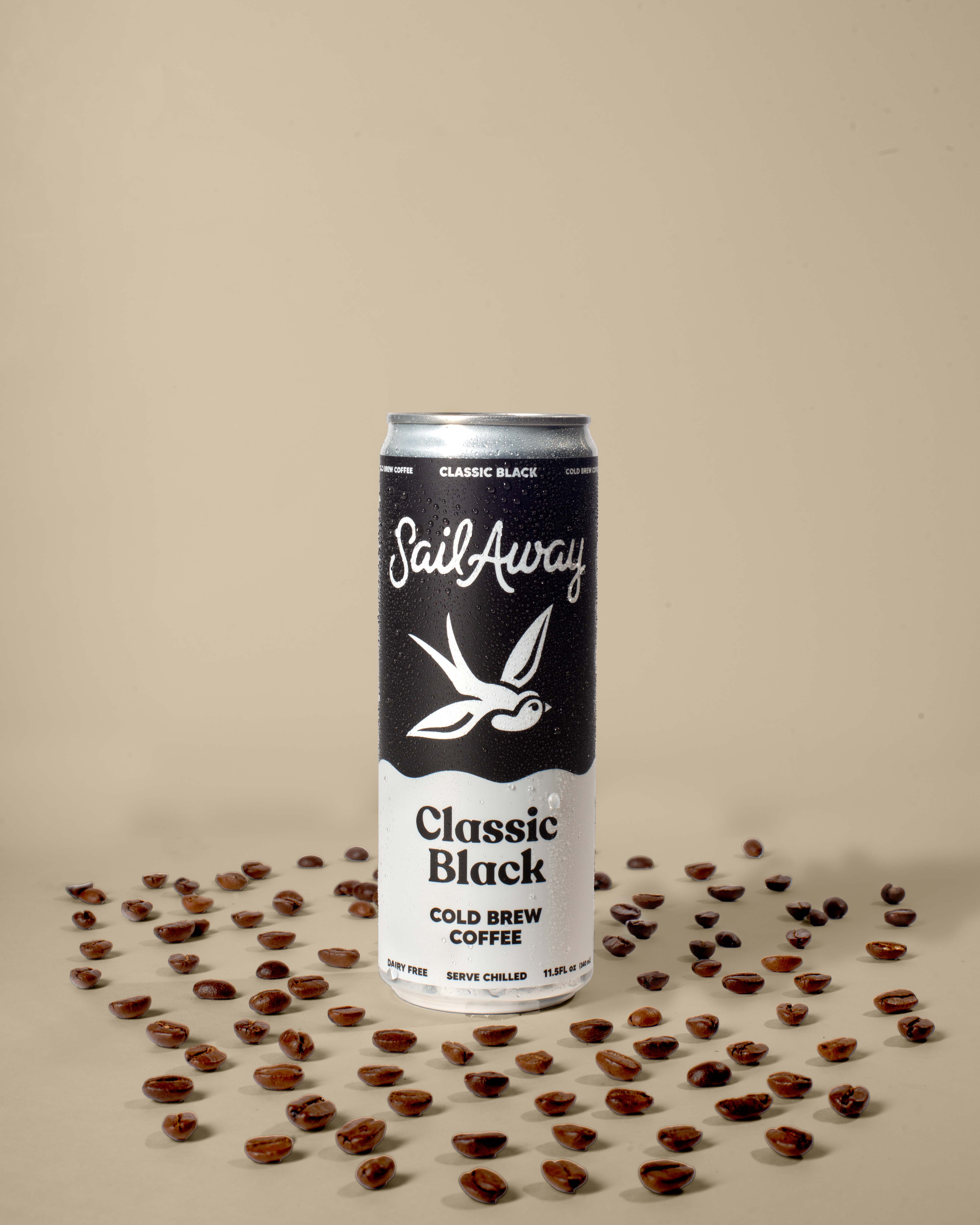Can of SailAway Classic Black Cold Brew Coffee surrounded by coffee beans on a beige background